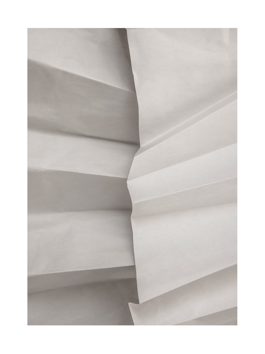 Fotografie von gefaltetem Papier in Weiß und Hellgrau.