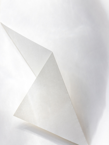 Minimalistisches Poster mit gefaltetem Papier und subtilen Schatten.