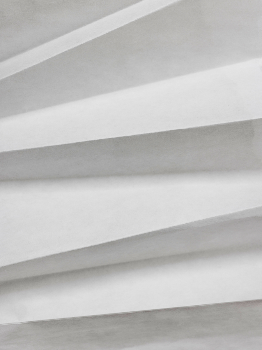 Fotografie eines abstrakten Faltenmusters in Weiß und Grau.