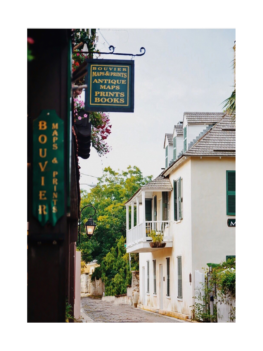 Fotografie des französischen Viertels in New Orleans mit einer Buchhandlung und einem Haus mit grünen Fensterläden.