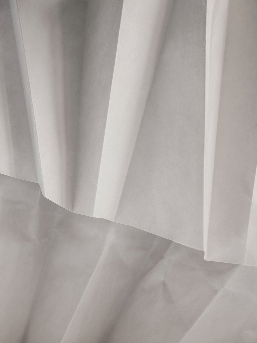 Nahaufnahme von grauem, gefaltetem Stoff.