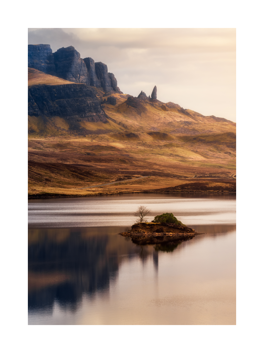 Fotografie eines Sees mit einer kleinen Insel und einem Berg im Hintergrund.