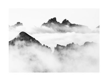 Schwarz-weiß-Fotografie von Berggipfeln im Nebel.