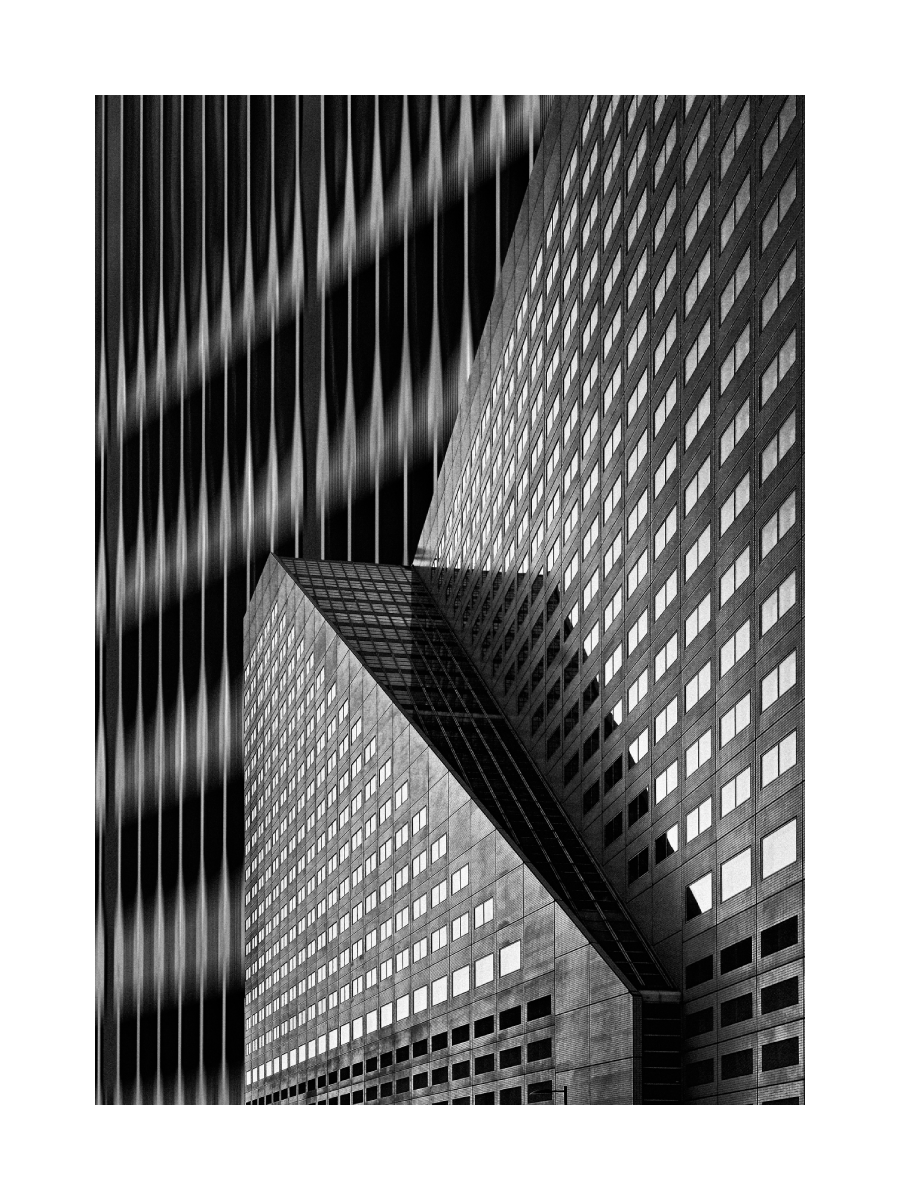 Schwarz-weiß-Fotografie eines Wolkenkratzers mit quadratischen Fenstern und einem Gebäude mit wellenförmiger Fassade.