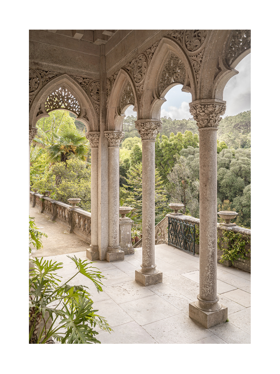 Fotografie eines Balkons mit Bögen und Blick auf einen grünen Garten.