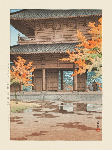 Ein traditioneller japanischer Holztempel umgeben von Herbstbäumen.