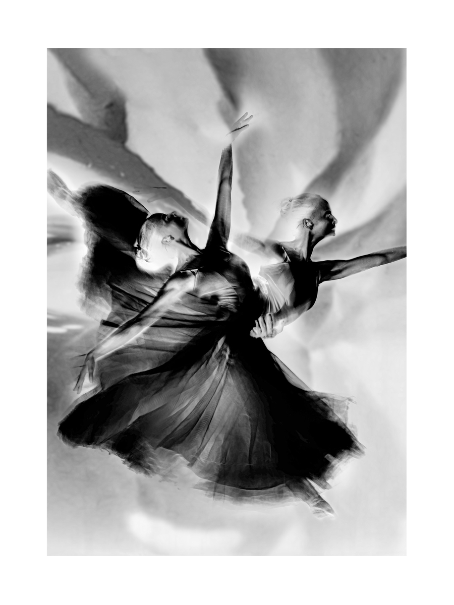 Schwarz-Weiß-Fotografie einer Ballerina in Bewegung, in negativer Darstellung.