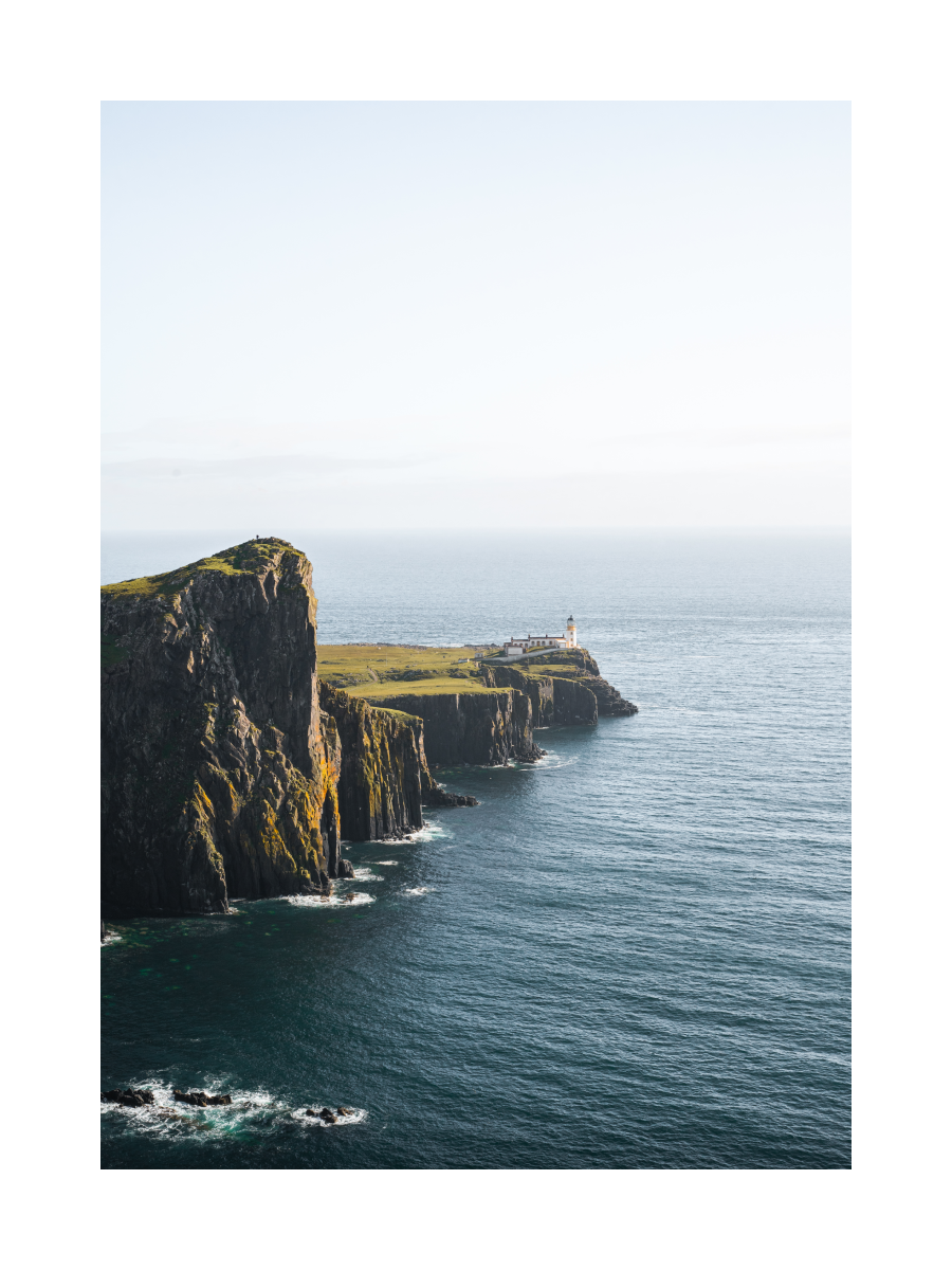 Fotografie eines weißen Leuchtturms auf einer Klippe am Meer bei Neist Point.