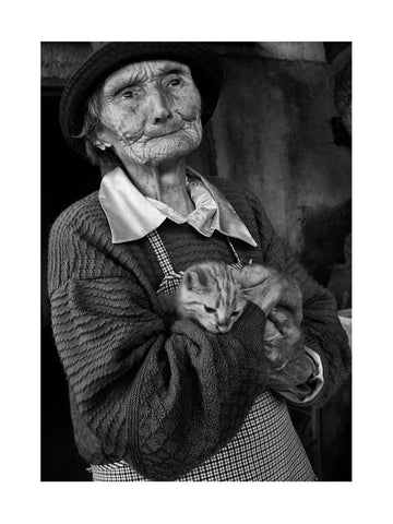 Schwarzweißfoto einer älteren Frau, die eine Katze hält.
