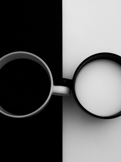 Schwarz-Weiß-Poster mit zwei Tassen, eine mit Kaffee auf schwarzem Hintergrund und eine mit Milch auf weißem Hintergrund.