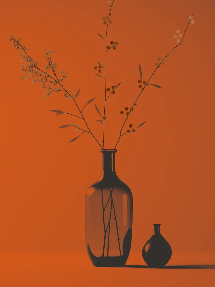 Zwei schwarze Vasen mit getrockneten Blumen auf einem Tisch vor einem orangefarbenen Hintergrund.