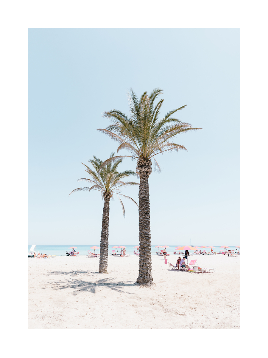 Fotografie von zwei Palmen an einem Strand mit Menschen und rosa Sonnenschirmen.