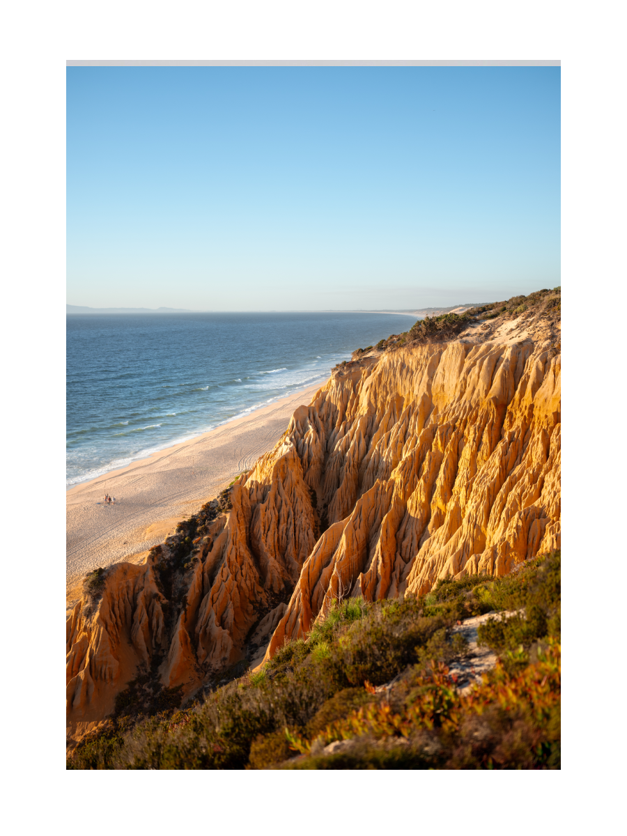 Fotografie von goldenen Klippen und azurblauem Meer an der Praia da Galé in Portugal.