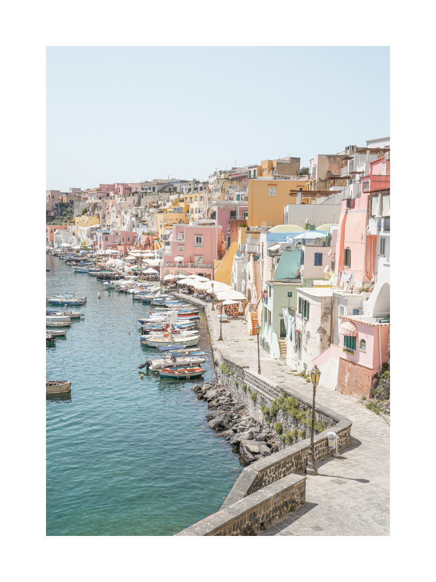 Fotografie der Insel Procida mit bunten Häusern und einem Hafen mit Booten.