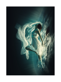 Frau in einem weißen Kleid schwebt unter Wasser in blauem Licht.