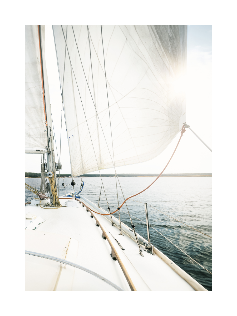 Fotografie eines Segelboots auf einem See mit der Sonne im Hintergrund.