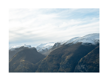 Fotografie von schneebedeckten Bergen unter einem blauen Himmel.