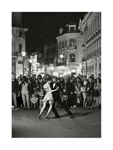 Schwarz-weiß-Fotografie eines tanzenden Paares auf der Straße, umgeben von einer Menschenmenge.