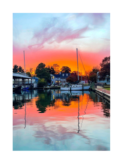 Fotoposter eines Sonnenuntergangs über einem Hafen mit Spiegelung im Wasser.