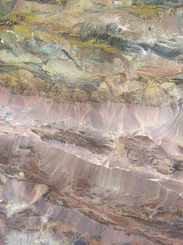 Satellitenbild der Taklamakan-Wüste mit rosa, braunen und grünen Tönen.