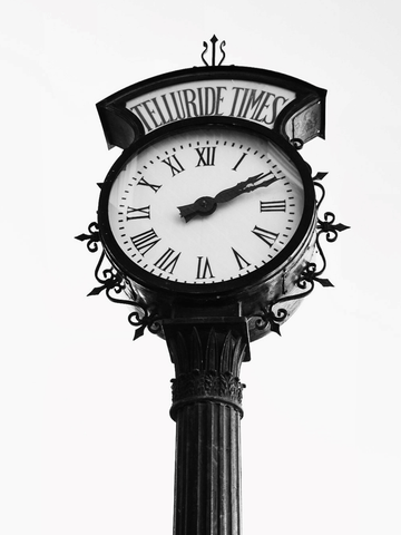 Schwarz-weiß-Fotografie einer Retro-Standuhr mit römischen Ziffern und der Aufschrift „Telluride Times“.