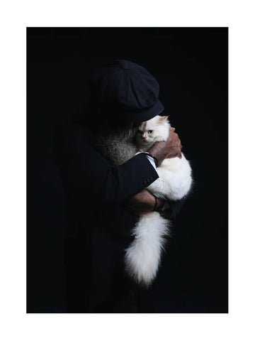 Eine Person hält eine weiße Katze vor einem dunklen Hintergrund.