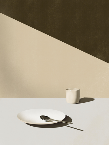 Fotografie eines Tellers mit Löffel und geometrischem Hintergrund in Beige- und Olivtönen.