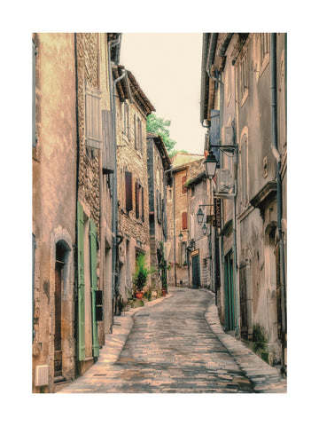 Fotografie einer schmalen Straße mit alten Gebäuden und Laternen in Frankreich.