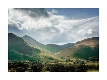 Fotografie der grünen Hügel im Lake District unter einem dramatischen Himmel.