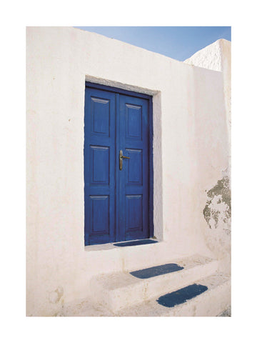 Fotografie einer blauen Tür mit blauen Stufen in einem weißen Gebäude.