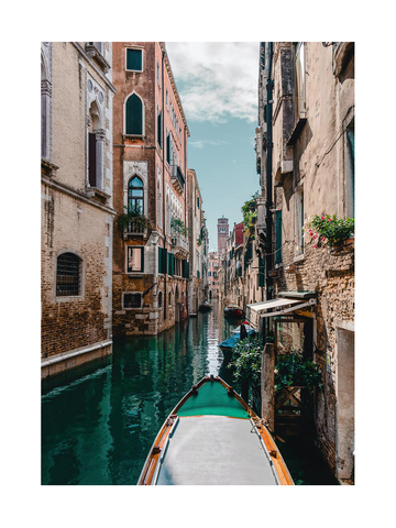 Fotografie einer Gondel in einem venezianischen Kanal mit alten Gebäuden und blauem Himmel.