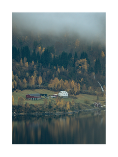 Landschaft mit einem See, einem Dorf und herbstlichen Bäumen im Nebel.