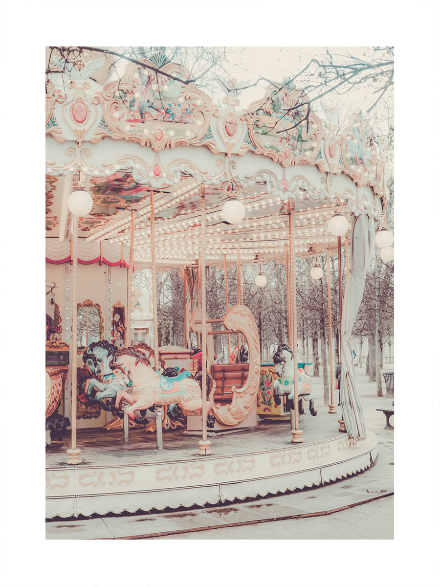 Fotografie eines Karussells mit Pferden in Rosa und Blau, mit Bäumen im Hintergrund.
