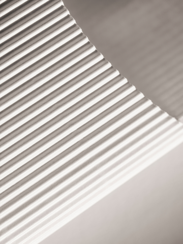 Fotografie von Papier mit wellenförmigem Muster in neutralen Farbtönen.