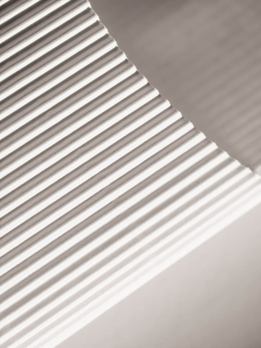 Fotografie von Papier mit wellenförmigem Muster in neutralen Farbtönen.