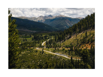 Eine kurvige Landstraße durch grüne Wälder und Berge.